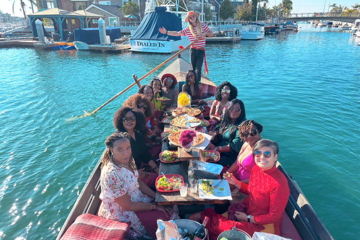 a group of people sitting on a dock next to a body of water