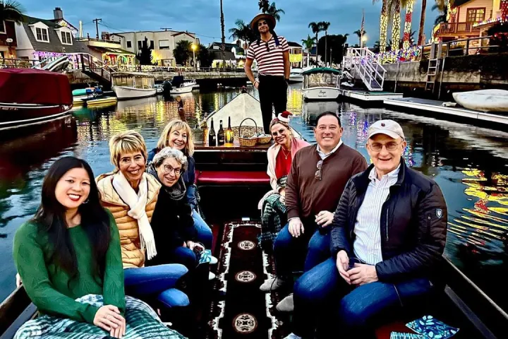 Group of people sitting on a gondola at twilight in festive surroundings.